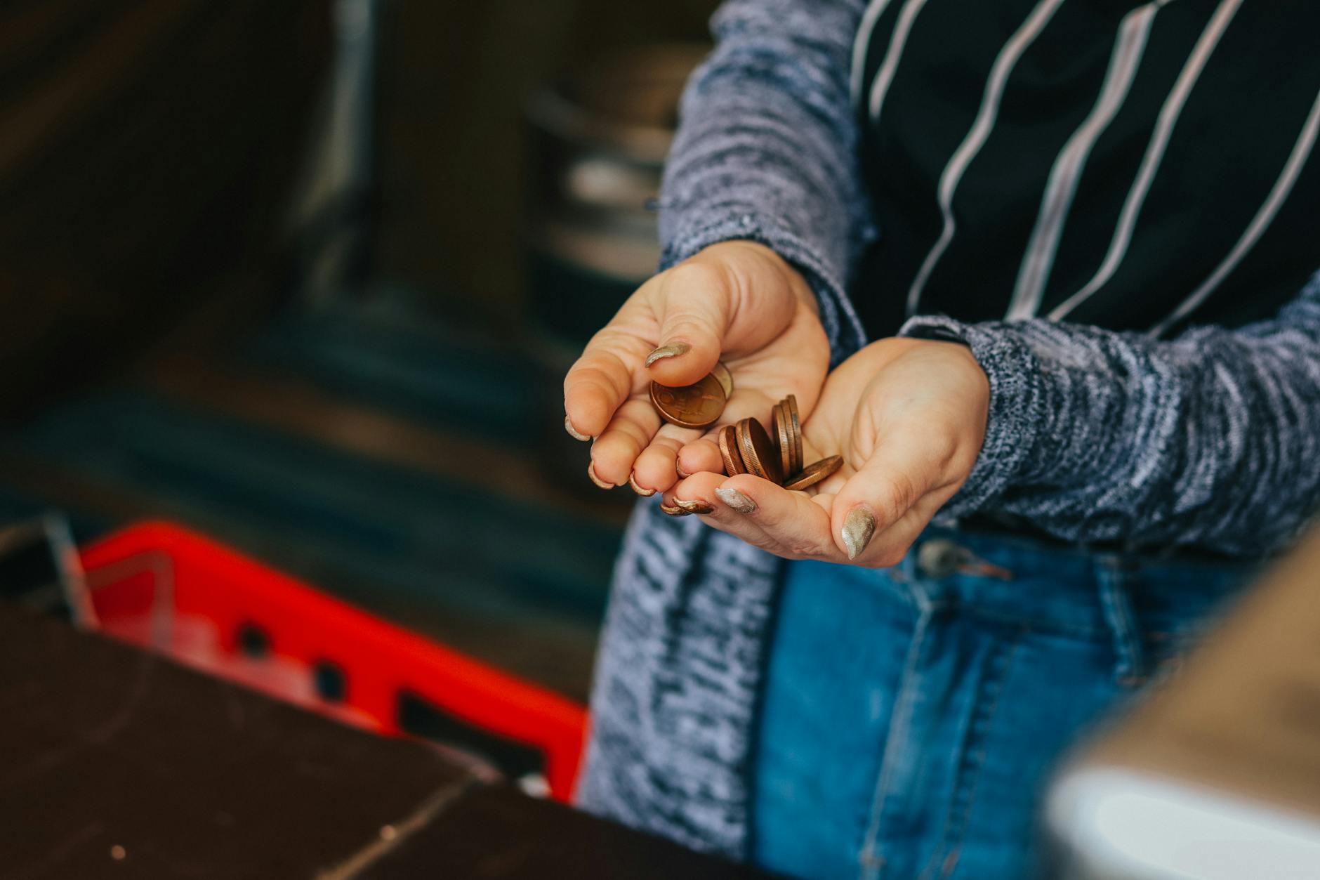 Close-up of a person's hands holding loose change at a Prague market.